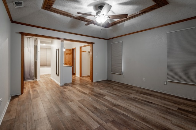 interior space featuring a textured ceiling, crown molding, visible vents, ceiling fan, and wood finished floors