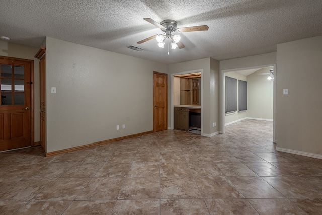 unfurnished room with baseboards, visible vents, a ceiling fan, and a textured ceiling