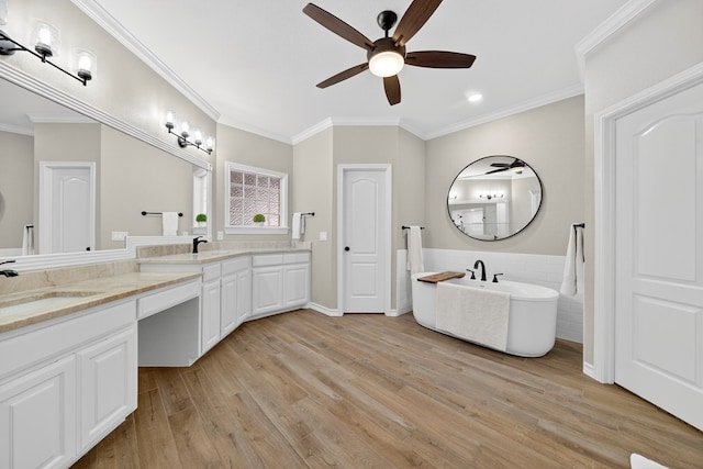 5703 Devlin Pl, Midland, TX 79707 - bathroom featuring ceiling fan, wood finished floors, double vanity, a soaking tub, and crown molding