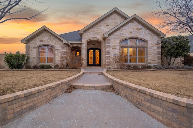 french country home featuring a yard and french doors