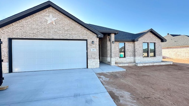 view of front of property with brick siding, concrete driveway, a garage, and a shingled roof