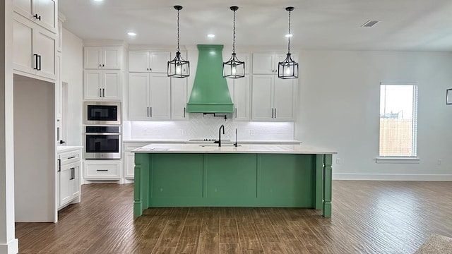 kitchen featuring visible vents, premium range hood, light countertops, decorative backsplash, and appliances with stainless steel finishes