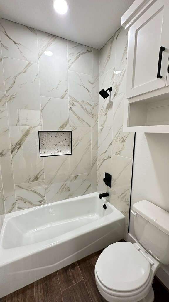 full bath with recessed lighting, shower / bath combination, toilet, and wood tiled floor