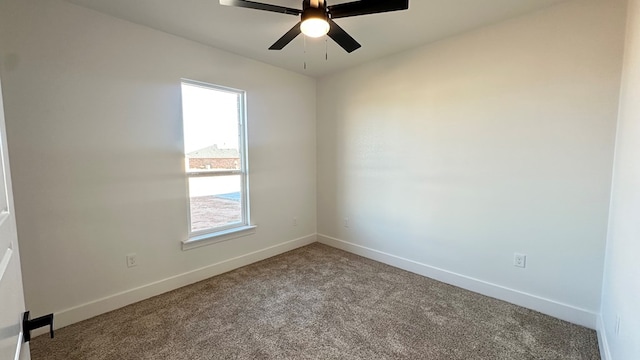 carpeted spare room with ceiling fan and baseboards