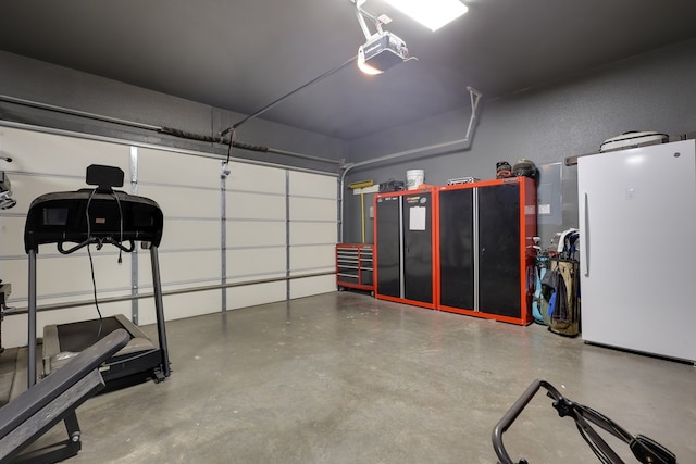 garage featuring freestanding refrigerator and a garage door opener