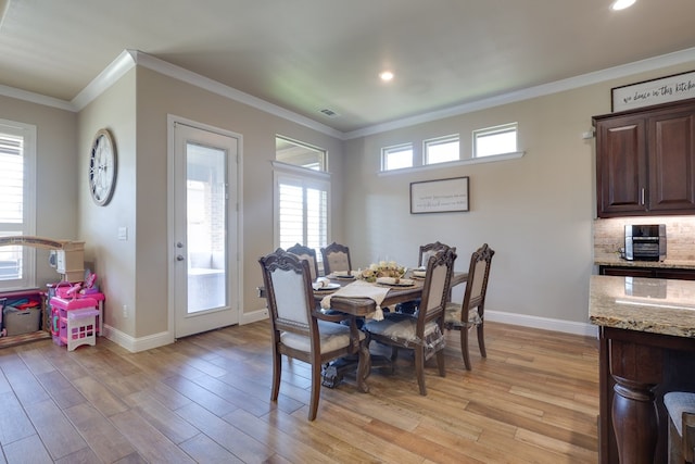 dining room with crown molding, light wood finished floors, baseboards, healthy amount of natural light, and recessed lighting