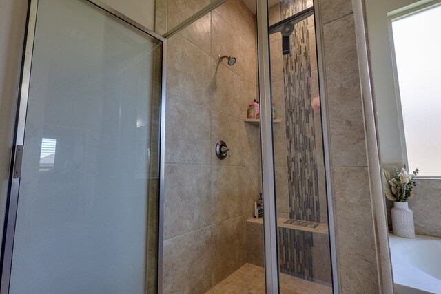 full bathroom with a stall shower and a bath