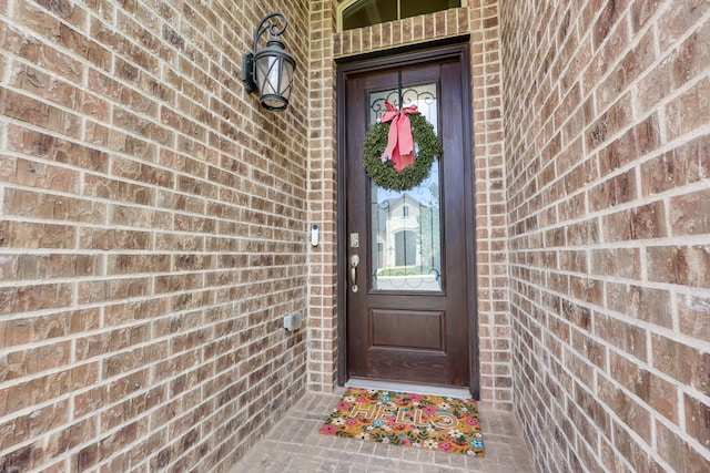 view of exterior entry with brick siding