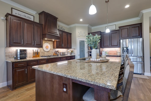 kitchen with appliances with stainless steel finishes, light stone countertops, light wood-style floors, crown molding, and recessed lighting