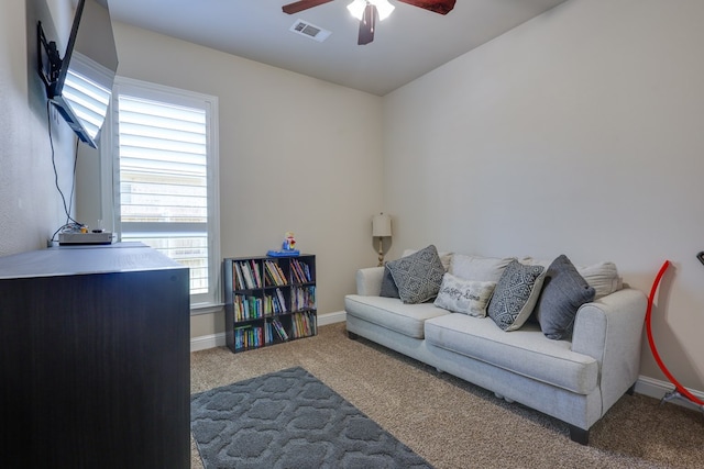living area featuring ceiling fan, carpet flooring, and baseboards