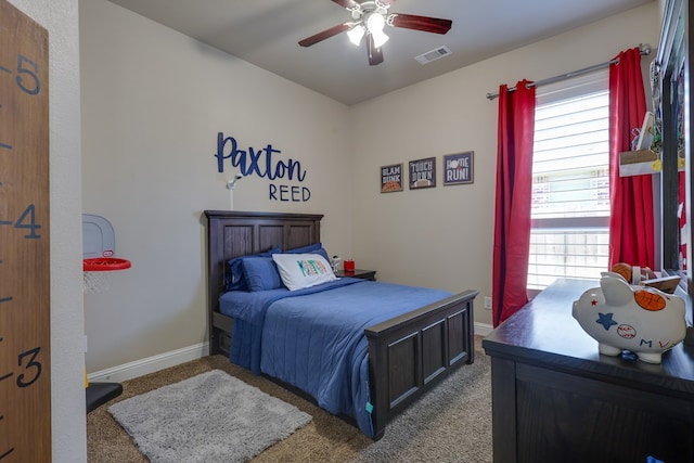 carpeted bedroom with multiple windows, baseboards, and a ceiling fan