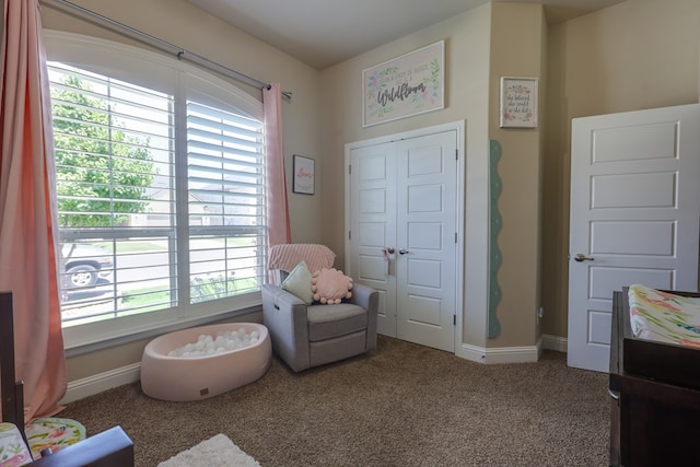 sitting room featuring healthy amount of natural light, carpet, and baseboards
