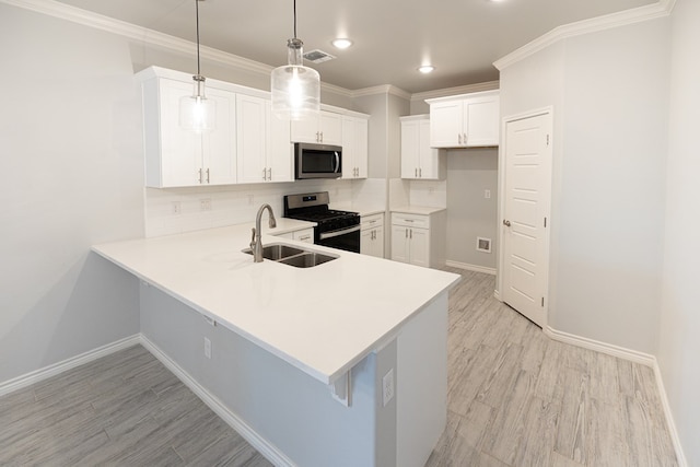 5312 Kilyn Ct, Midland, TX 79703 - kitchen featuring appliances with stainless steel finishes, a sink, a peninsula, light wood-style flooring, and baseboards