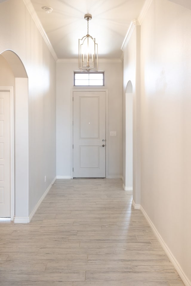 5312 Kilyn Ct, Midland, TX 79703 - doorway featuring arched walkways, a chandelier, crown molding, light wood finished floors, and baseboards