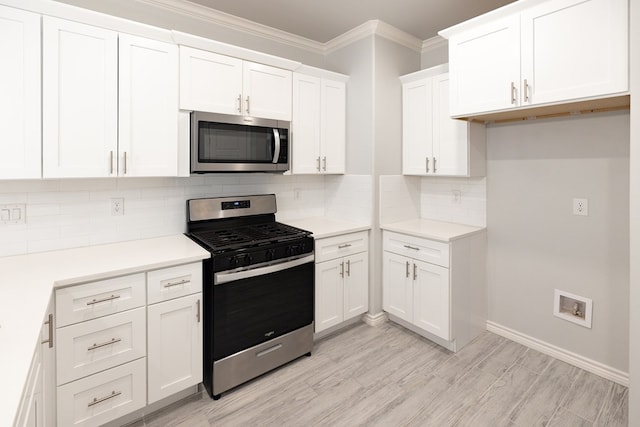 5312 Kilyn Ct, Midland, TX 79703 - kitchen featuring appliances with stainless steel finishes, white cabinetry, backsplash, crown molding, and light countertops