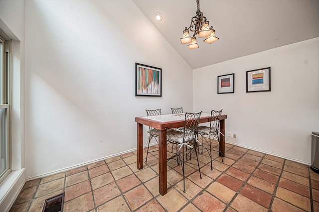 dining space with lofted ceiling and a notable chandelier