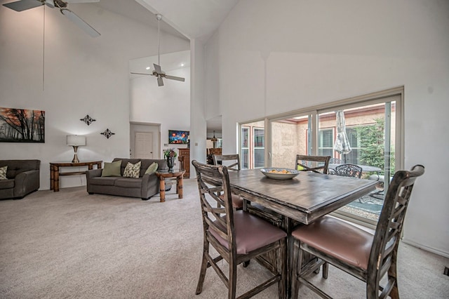 carpeted dining room with ceiling fan and high vaulted ceiling