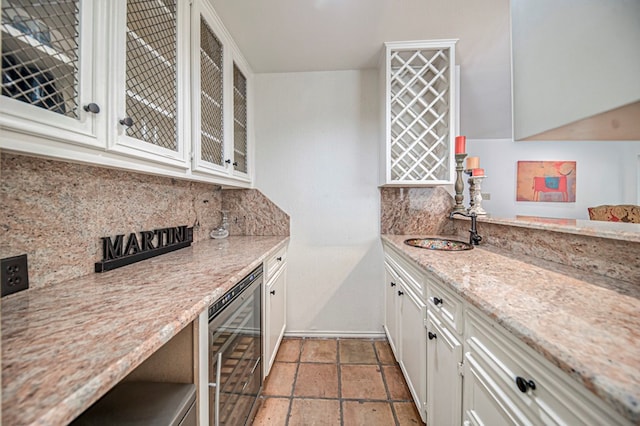 kitchen featuring white cabinets, decorative backsplash, wine cooler, and light stone countertops