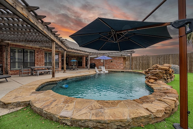 pool at dusk with a patio area