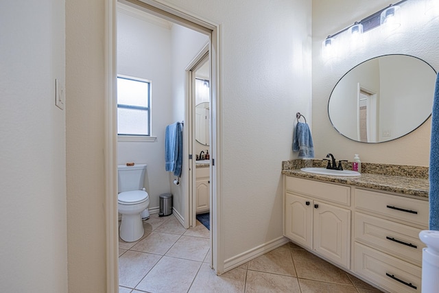 bathroom with tile patterned flooring, vanity, and toilet