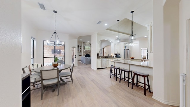 dining room with sink, light hardwood / wood-style floors, and a chandelier