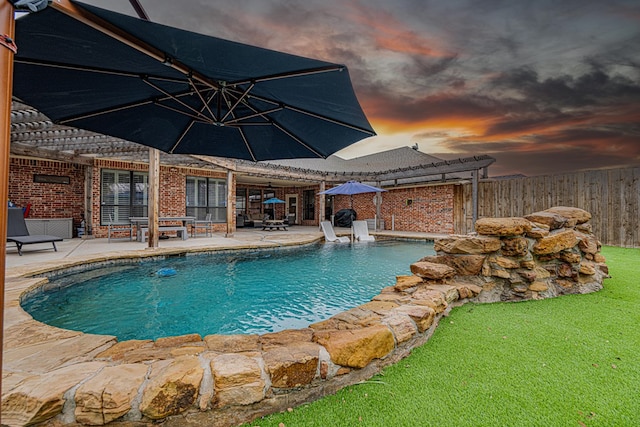 pool at dusk featuring a pergola and a patio area