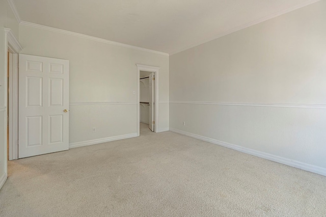 unfurnished bedroom with light colored carpet, crown molding, and a closet