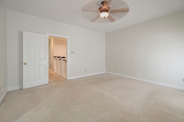 spare room with ceiling fan and light colored carpet