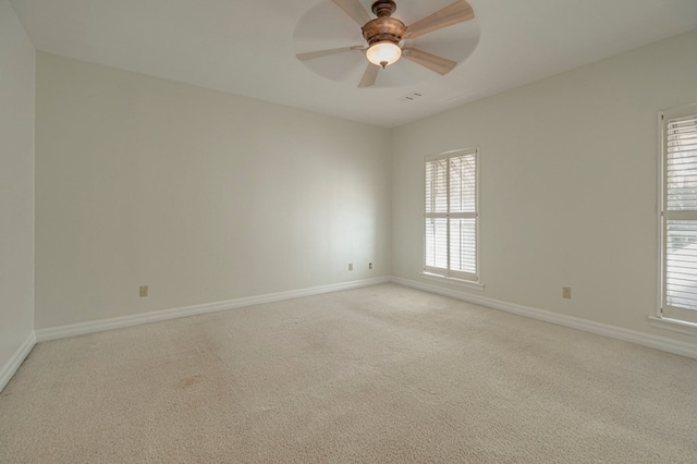 unfurnished room featuring ceiling fan, plenty of natural light, and light colored carpet