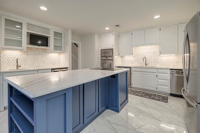 kitchen featuring white cabinetry, sink, a kitchen island, and light stone counters