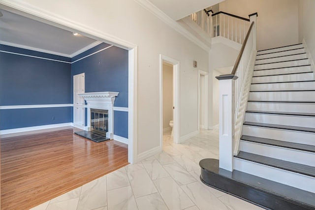 staircase with hardwood / wood-style flooring and ornamental molding