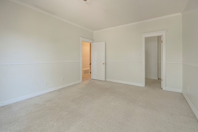 empty room featuring crown molding and light carpet