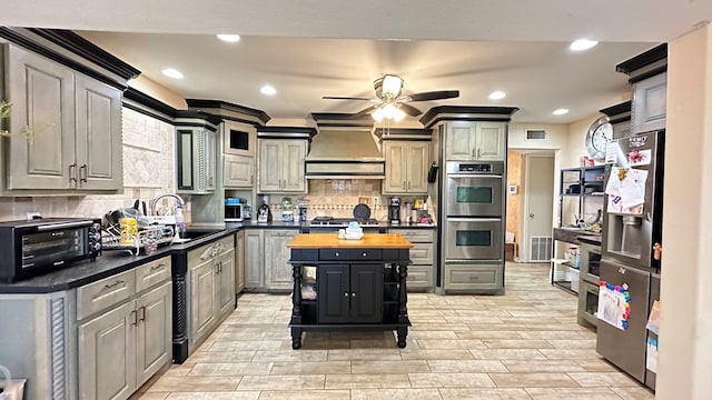 kitchen featuring butcher block countertops, gray cabinets, and premium range hood