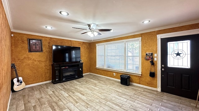 entryway with a fireplace, light hardwood / wood-style floors, ceiling fan, and ornamental molding