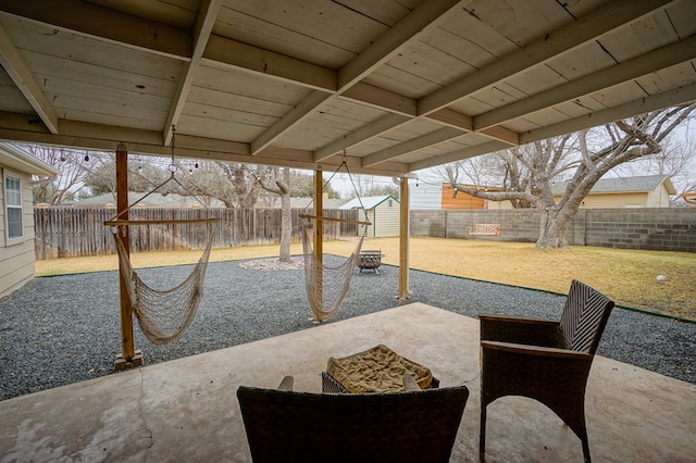 view of patio with an outdoor fire pit and a storage unit