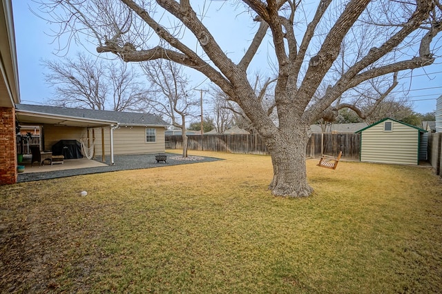 view of yard featuring a storage shed and a patio area