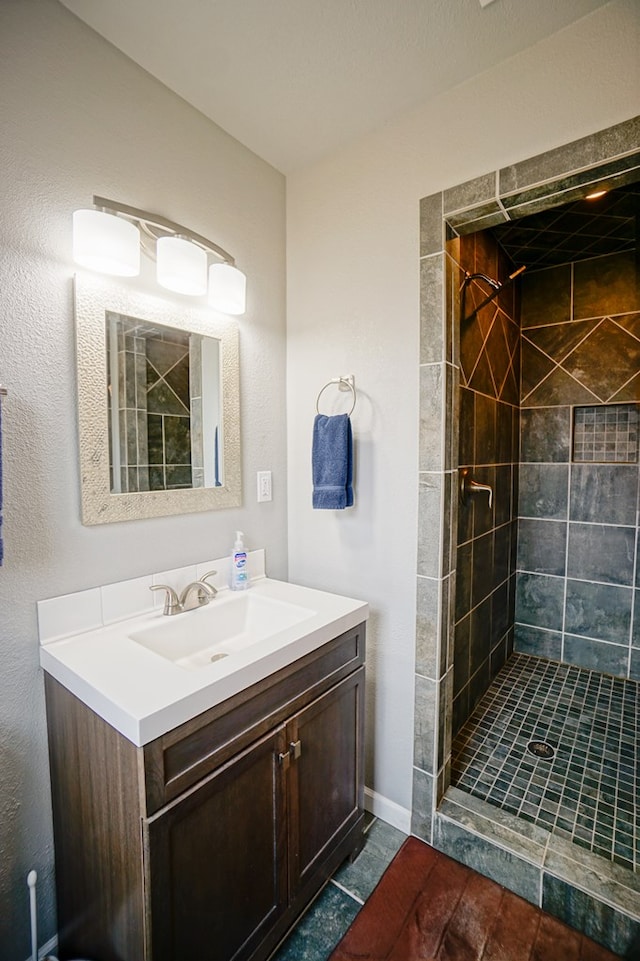 bathroom featuring vanity and tiled shower