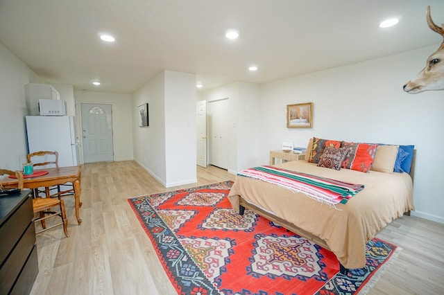 bedroom with white refrigerator and light wood-type flooring