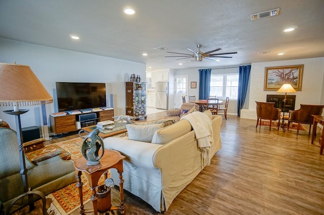 living room featuring light hardwood / wood-style flooring and ceiling fan