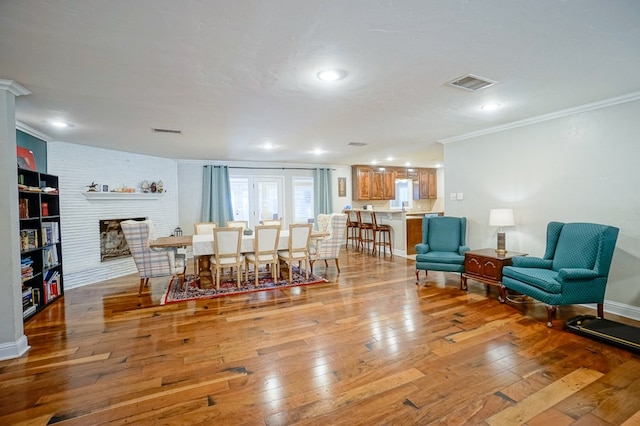 living room with ornamental molding, a fireplace, and light hardwood / wood-style flooring