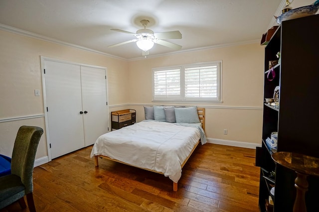 bedroom featuring wood-type flooring, a closet, ceiling fan, and crown molding