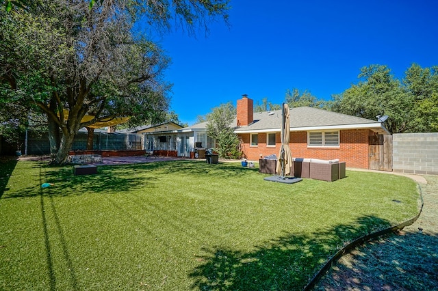 rear view of property featuring outdoor lounge area, a patio, and a lawn