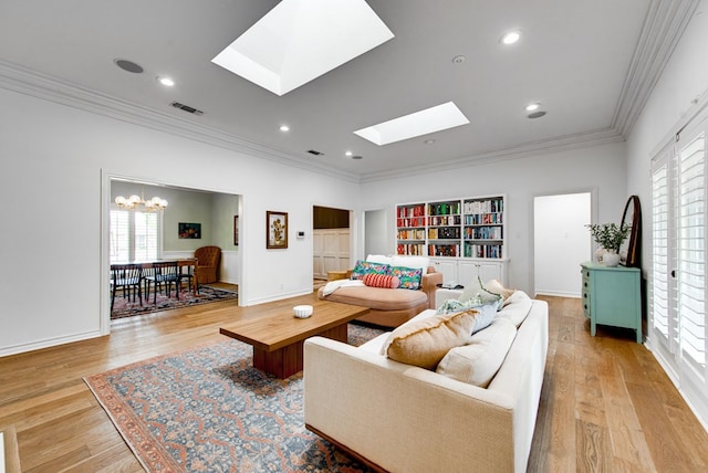 living room with ornamental molding, an inviting chandelier, light hardwood / wood-style floors, and a skylight