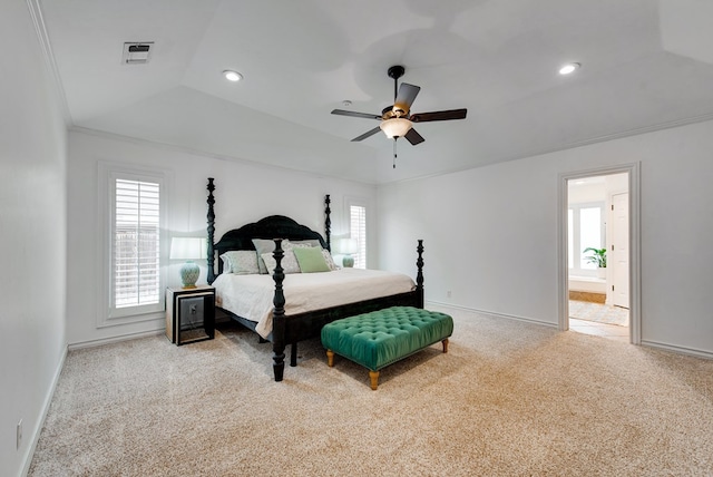 carpeted bedroom featuring crown molding, ensuite bath, ceiling fan, vaulted ceiling, and a raised ceiling