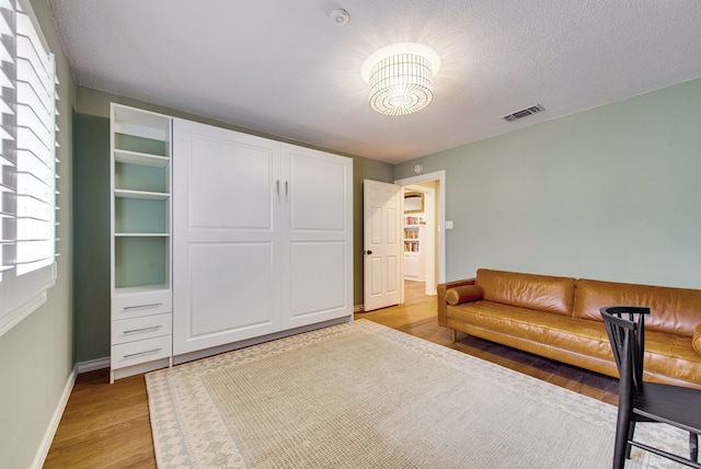 unfurnished room with a textured ceiling and light wood-type flooring