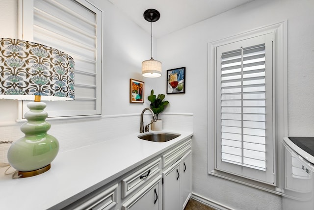 kitchen with sink, decorative light fixtures, and a healthy amount of sunlight