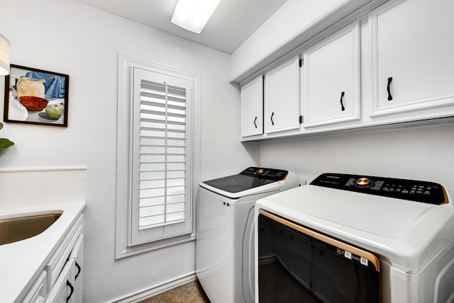 washroom with sink, washer and clothes dryer, and cabinets