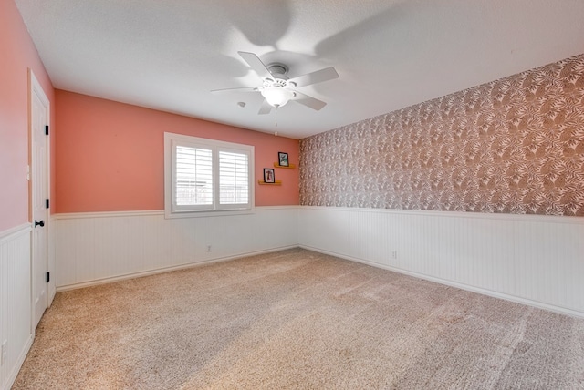 unfurnished room featuring ceiling fan, light carpet, and a textured ceiling