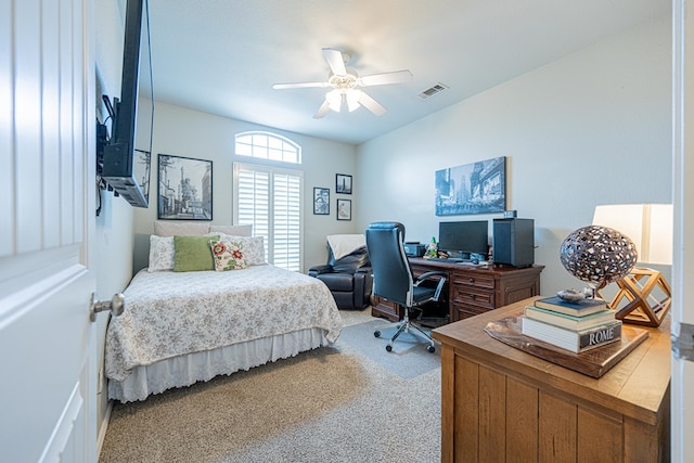 bedroom with an office area, light colored carpet, and ceiling fan