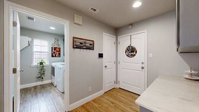 entryway with independent washer and dryer, light wood finished floors, baseboards, and recessed lighting